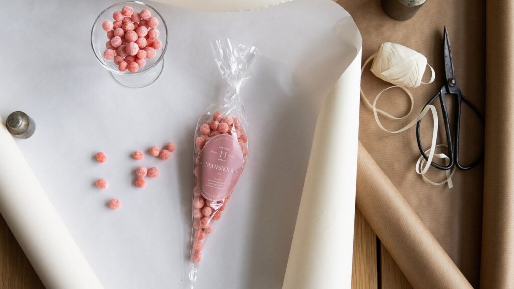 Light pink strawberry candies in a bowl and in a gift package.