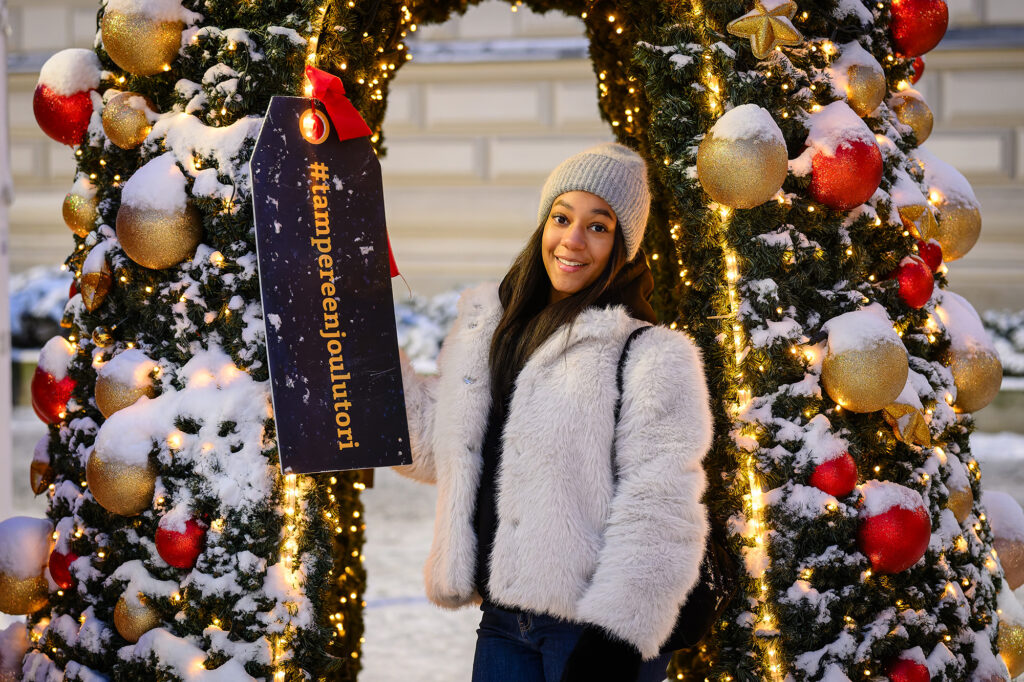 A person standing infront of christmas decoration.