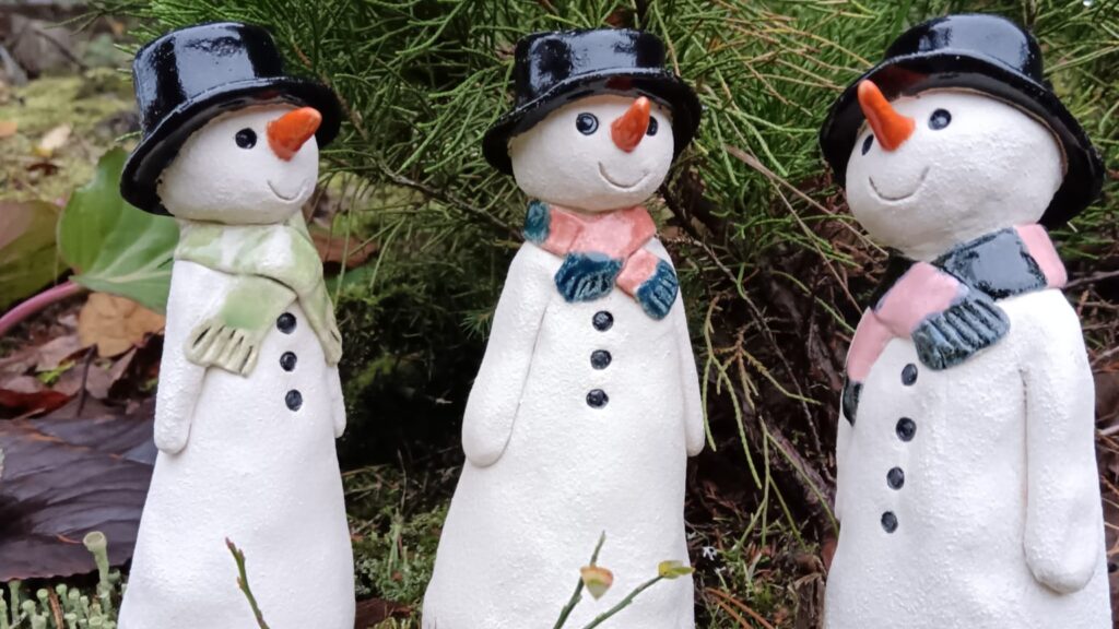 Set of three smiling ceramic snowmen.